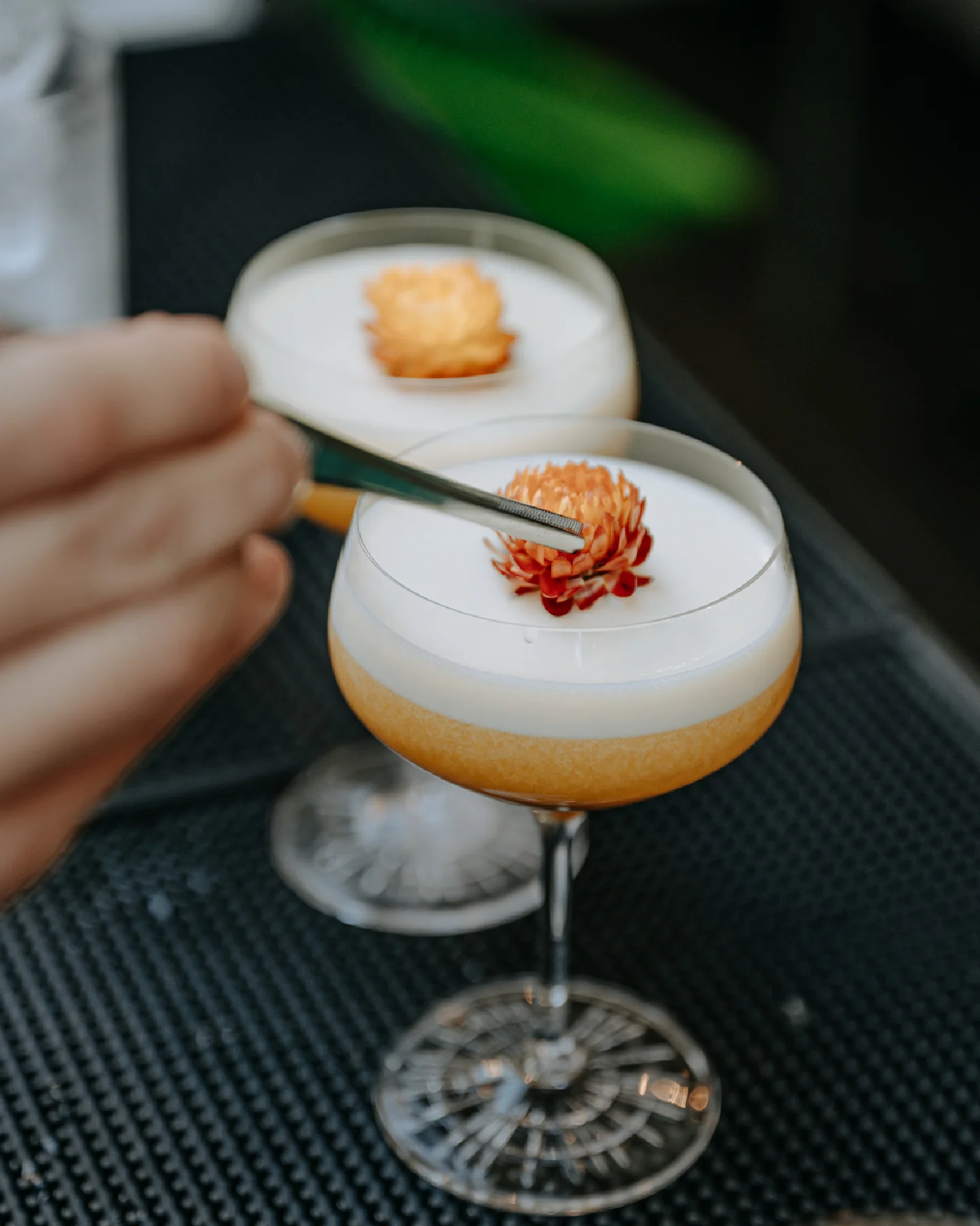 Bartender profesional decorando cócteles con espuma y flores para evento para consultoria de coctelería
