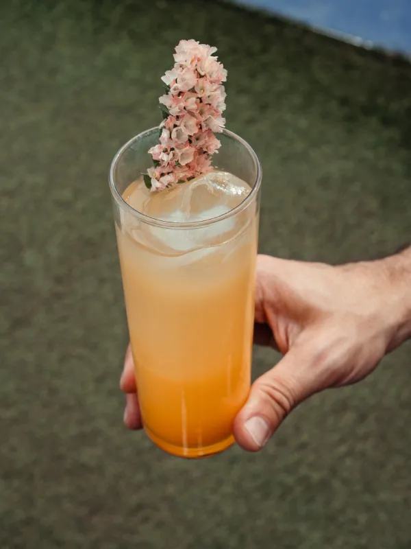 Cóctel de pomelo decorado con flores preparado por Bartenders Events