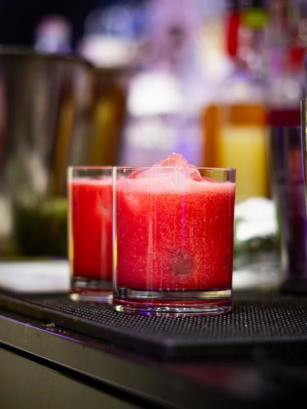 Cóctel rojo de sandia preparado en barra de coctelería para eventos
